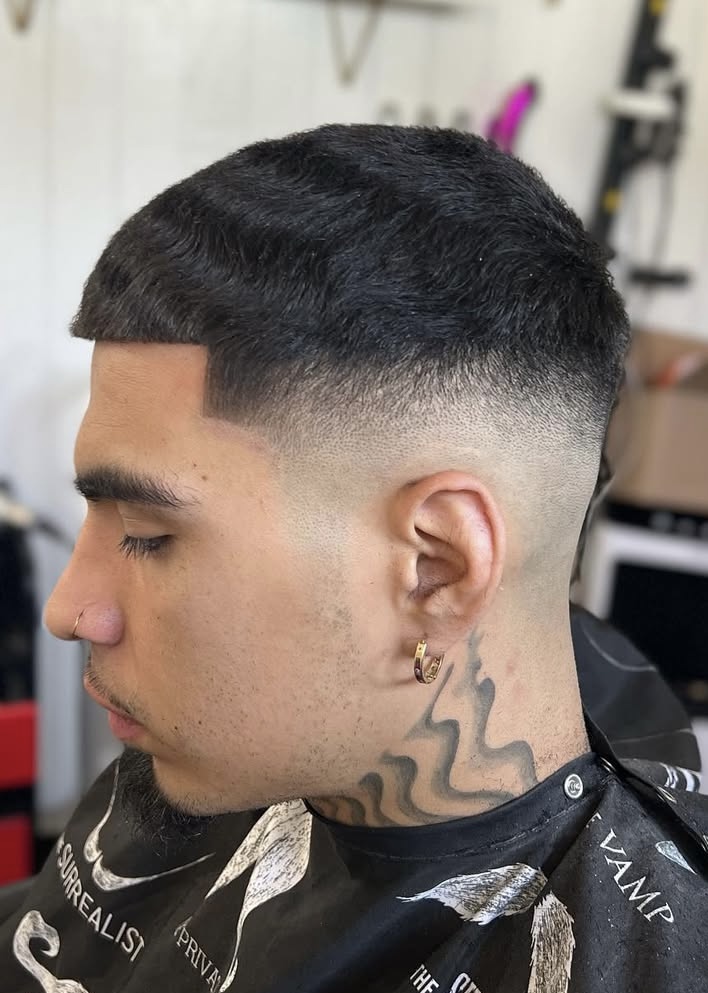 Low skin fade with textured top by Javistylz barber